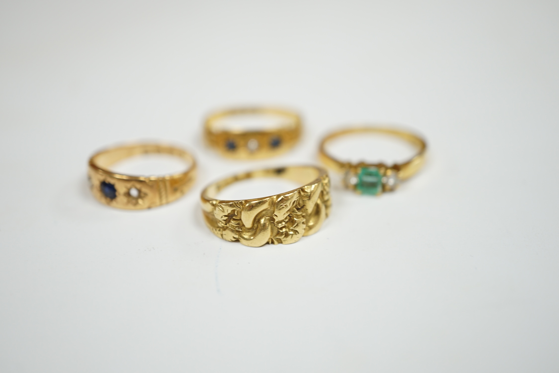 An Edwardian 18ct gold ring, size M, together with three other 18ct gold and gem set rings, including two early 20th century, gross weight 12.9 grams. Condition - fair